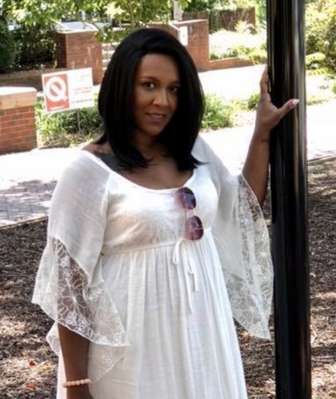 Kirstie outdoors wearing a white lace dress